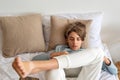 Teenager boy with laptop laying on bed with leg ankle-on-knee, playing game, surfing social media, watching video. Youth Royalty Free Stock Photo