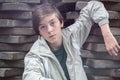 Teenager boy leaning on a stack of flagstones