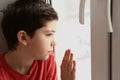 Teenager boy looking out of the window Royalty Free Stock Photo