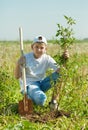 Teenager boy planting tree