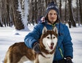 Teenager boy playing with white Husky dog in winter day, dog and child on snow Royalty Free Stock Photo