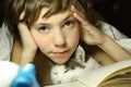 Teenager boy reading book with cat in bed Royalty Free Stock Photo