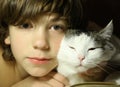 Teenager boy reading book with cat in bed Royalty Free Stock Photo