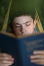 Teenager boy reading in hammock Royalty Free Stock Photo