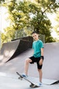 Teenager boy ready for ride on skate board on skateboard park playground. Sports equipment for kids. Extreme lifestyle. Royalty Free Stock Photo