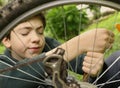 Teenager boy repair bicycle tire close up summer photo Royalty Free Stock Photo