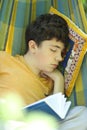 Teenager boy resting sleep with book in hammock on summer green garden Royalty Free Stock Photo