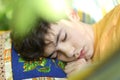 Teenager boy resting sleep with book in hammock on summer green garden Royalty Free Stock Photo