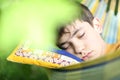 Teenager boy resting sleep with book in hammock on summer green garden Royalty Free Stock Photo