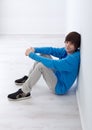 Teenager boy sitting by the wall Royalty Free Stock Photo