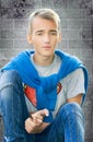 Teenager boy sitting at the wall closeup. Royalty Free Stock Photo