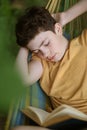 Teenager boy sleeping while reading in hammock Royalty Free Stock Photo