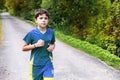 Teenager boy in sportswear run on the country road