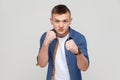 Teenager boy standing with boxing fists and ready to attack or defence, looking with angry face. Royalty Free Stock Photo