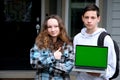 teenager boy teenager girl dancing rejoicing showing fingers green screen chroma key on computer on shoulders backpack Royalty Free Stock Photo