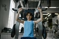 Teenager Boy Training Arms, Chest, Shoulders And Back On Exercise Machine