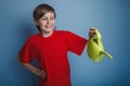 Teenager boy twelve years in a red shirt holding a Royalty Free Stock Photo