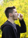 Teenager boy using asthma inhaler in park, Pollen allergy Royalty Free Stock Photo