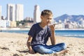 Teenager boy using a smart phone voice recognition function online, using cell phone to send a voice message outdoors Royalty Free Stock Photo