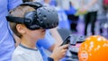 Teenager boy using virtual reality headset at technology show