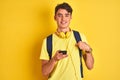 Teenager boy wearing headphones and using smartphone over isolated background with surprise face pointing finger to himself Royalty Free Stock Photo