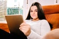 Teen girl reading on the tablet sitting on the sofa Royalty Free Stock Photo