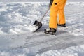 Teenager brush snow with shovel on ice of forest lake for ice skating. Healthy lifestyle