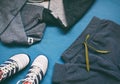 Teenager casual outfit. Boys shoes, clothing and accessories on blue background - sweater, trousers, sneakers. Top view. Flat lay Royalty Free Stock Photo