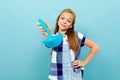 Teenager caucasian girl is going to cook something with kitchenware isolated on blue background