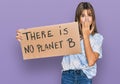 Teenager caucasian girl holding there is no planet b banner covering mouth with hand, shocked and afraid for mistake Royalty Free Stock Photo