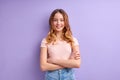 Teenager caucasian girl isolated on purple background keeping arms crossed in frontal position