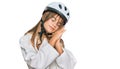 Teenager caucasian girl wearing bike helmet sleeping tired dreaming and posing with hands together while smiling with closed eyes Royalty Free Stock Photo