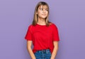 Teenager caucasian girl wearing casual red t shirt smiling looking to the side and staring away thinking