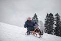 Teenager caught riding on a wooden sledge trying to adjust his direction with his hand and concentrating on his ride. In winter,