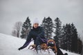 Teenager caught riding on a wooden sledge trying to adjust his direction with his hand and concentrating on his ride. In winter,