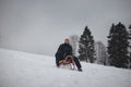 Teenager caught riding on a wooden sledge trying to adjust his direction with his hand and concentrating on his ride. In winter,