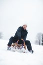 Teenager caught riding on a wooden sledge trying to adjust his direction with his hand and concentrating on his ride. In winter,