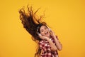 Teenager child girl in headphones listening music, wearing stylish casual outfit isolated over yellow background. Happy Royalty Free Stock Photo