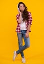 Teenager child girl in headphones listening music, wearing stylish casual outfit  over yellow background. Happy Royalty Free Stock Photo