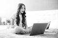 Teenager child girl working on laptop pc computer lying in bed resting relaxing in bedroom at home. teen girl. Surprised Royalty Free Stock Photo