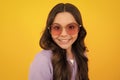 Teenager child with poor eyesight wear sunglasses, looking squinting. Kids glasses. Funny surprised adorable girl in