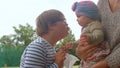 The teenager communicates with the girl in her mother's arms.