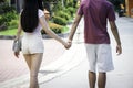 Teenager couple walking and holding hands together, spending time at theme park on summer weekend, young beautiful lover hanging