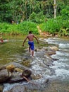 Teenager crossing the river in Ubatuba, Brazil