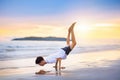 Teenager doing calisthenics exercise. Beach yoga