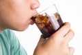 Teenager drinking a glass of refreshing cold fizzy cola drink