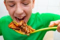 A teenager eagerly eats fatty fried meat, the concept of combining junk food