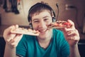 Teenager eating pizza sitting at a laptop. Royalty Free Stock Photo