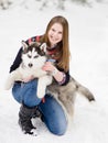 Teenager embracing hasky dog on snow