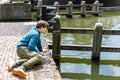 A teenager is fishing on a canal in Amsterdam Royalty Free Stock Photo